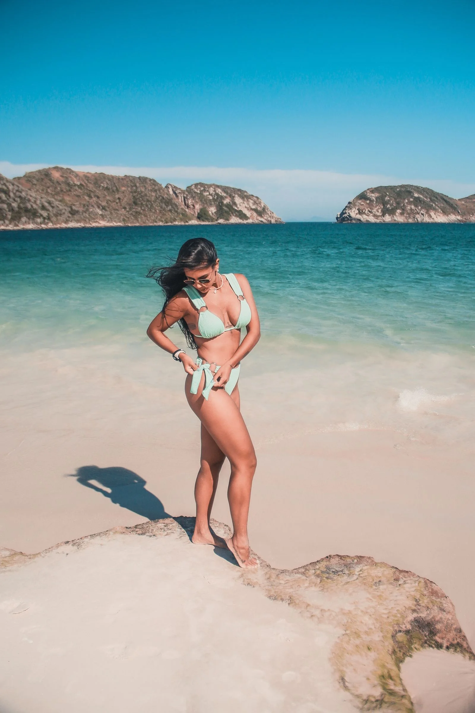 Adult woman wearing mint swimwear on a beach